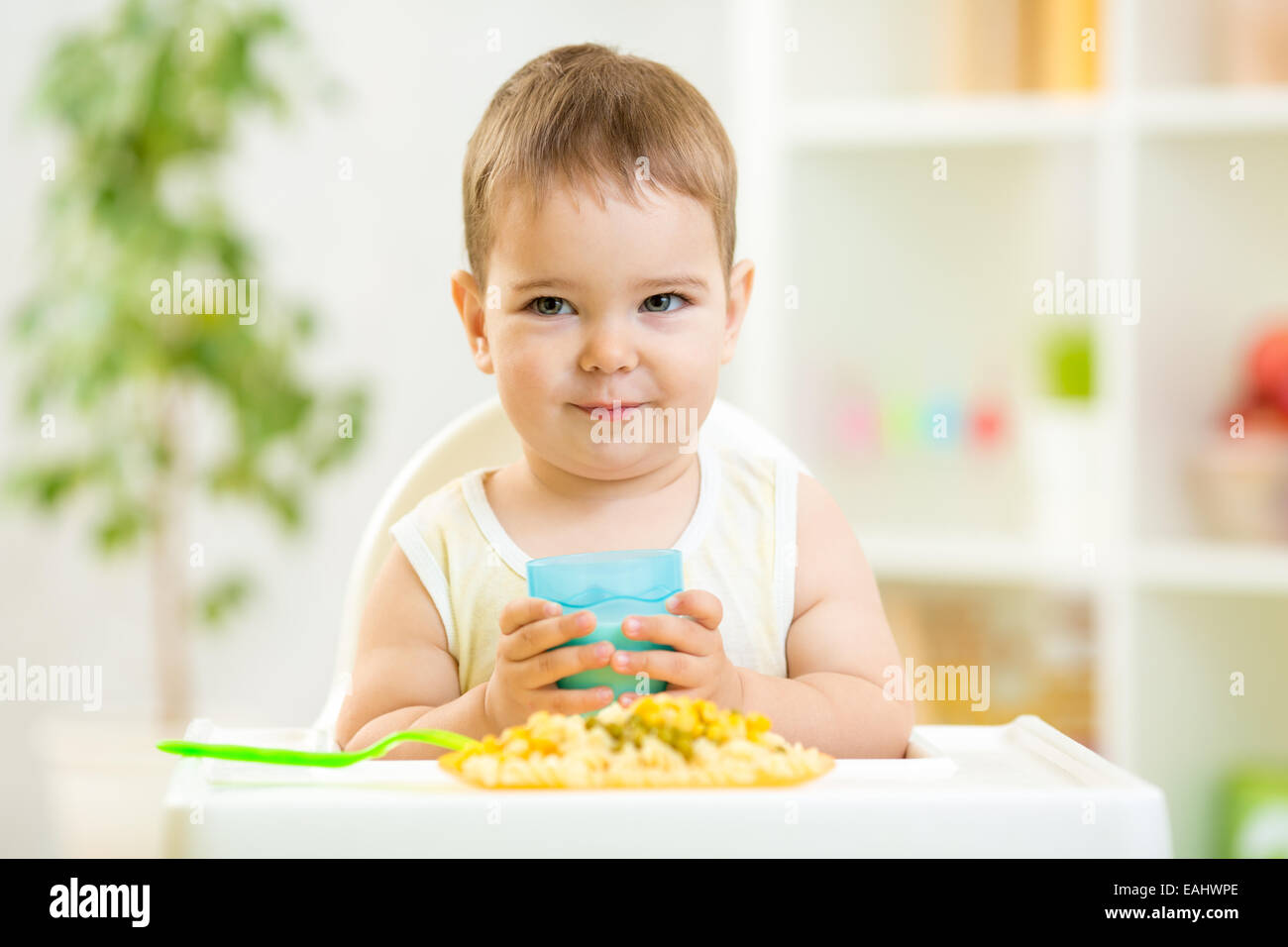 Baby boy bere latte in ambienti interni Foto Stock