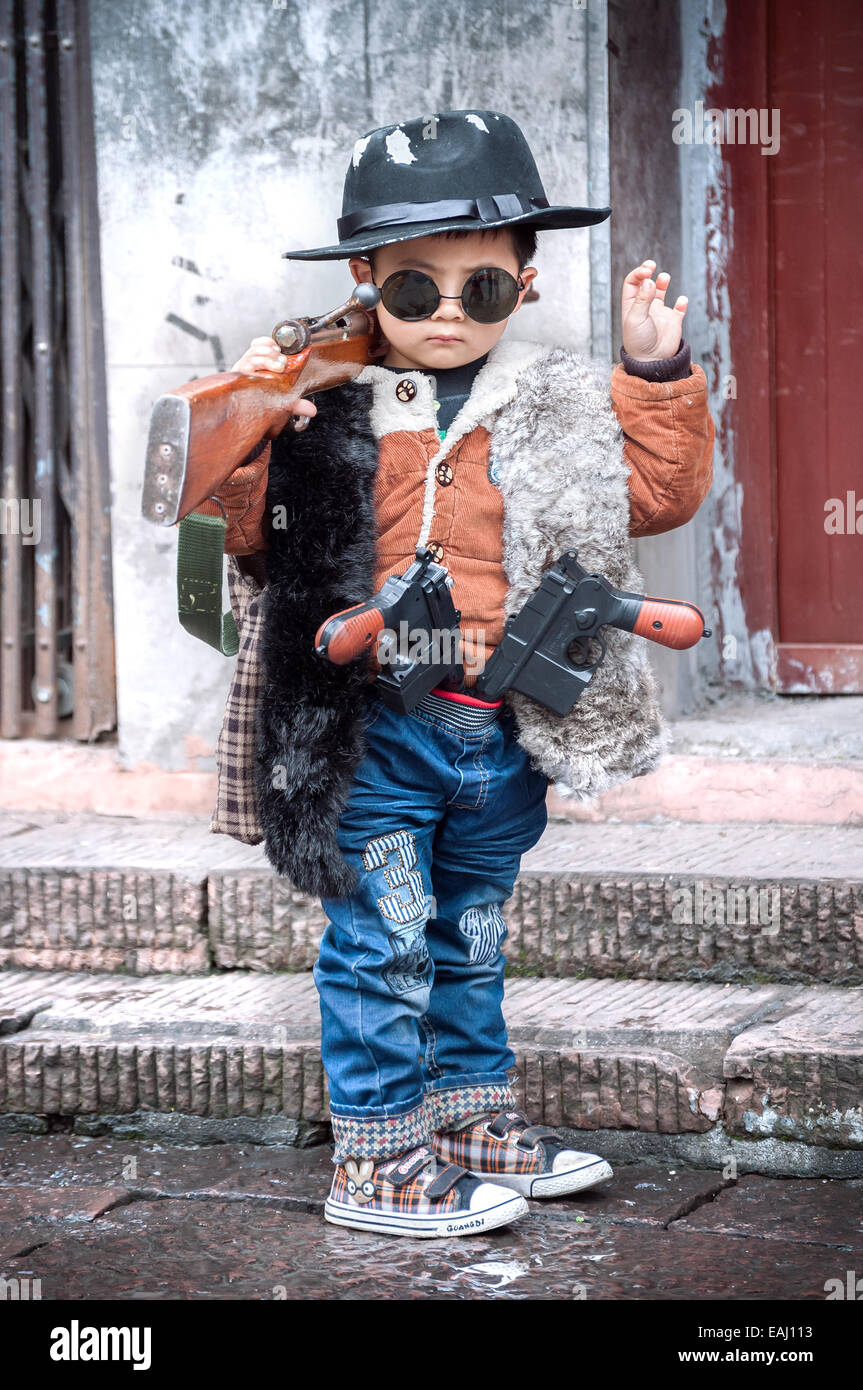 Carino kid vestito come un gangster in Fenghung antica città, provincia del Hunan, Cina Foto Stock