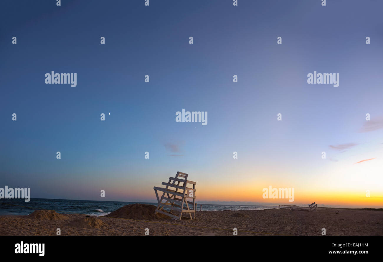 Summer in the Hamptons. Ponquogue Beach, Hampton baie, New York ora blu tramonto lifeguard sedie, il nastro della luna e Venere. Foto Stock