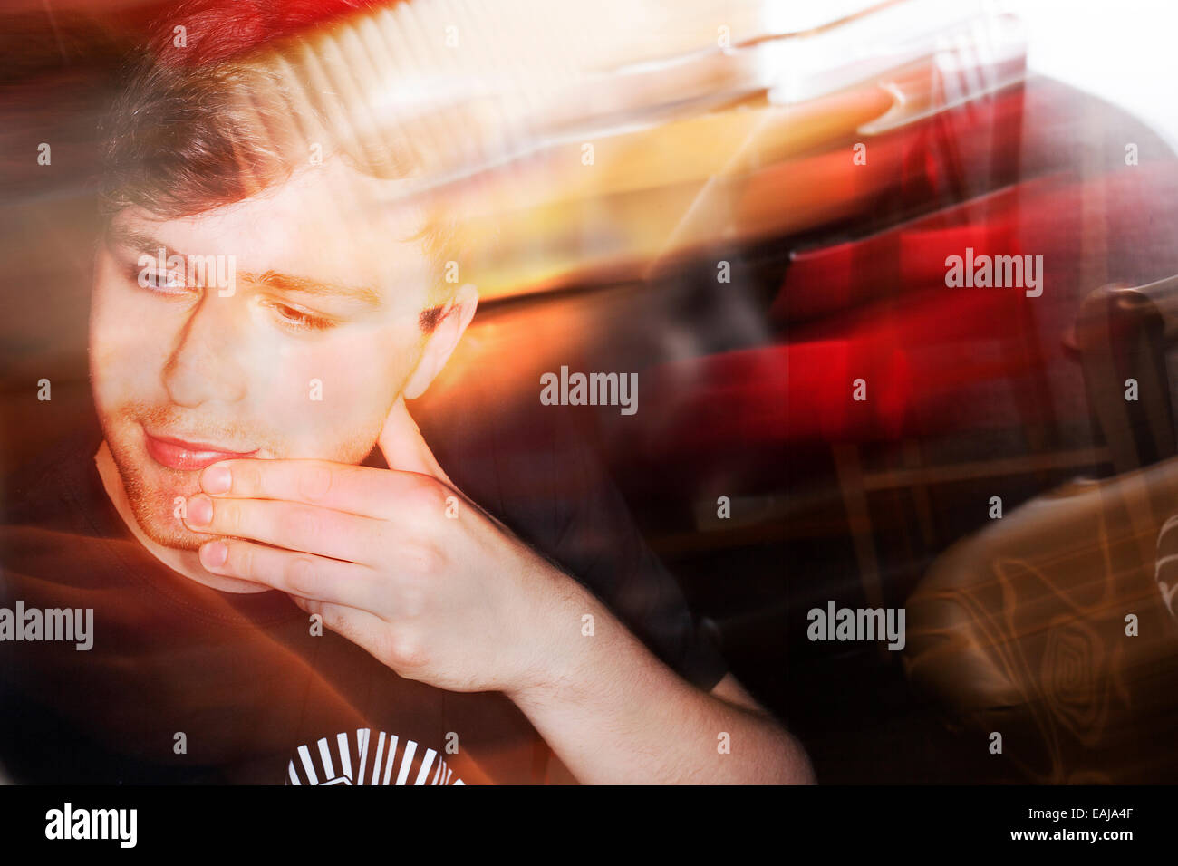 Un bianco maschio europeo età 19 in un caffè girato nel Regno Unito, l'immagine è a colori con flash blur Foto Stock