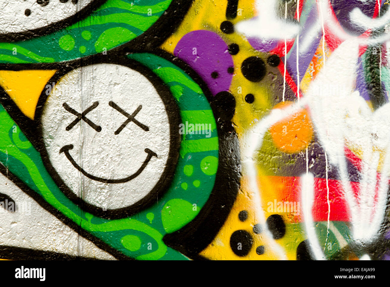 Tag Graffiti arte urbana del muro di Berlino in faccia felice Foto Stock