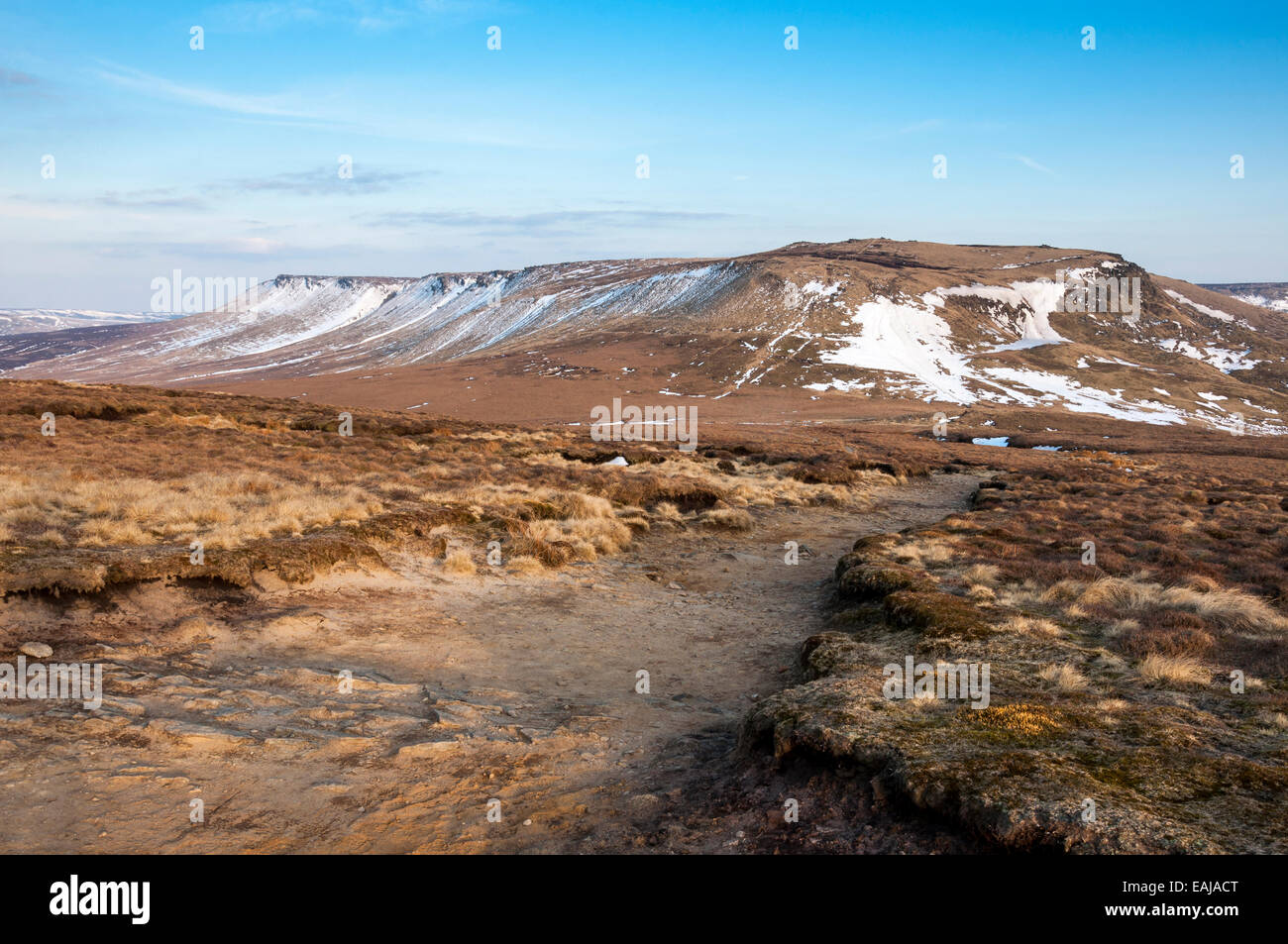 Drammatico paesaggio di brughiera con vista al Kinder Scout altopiano. Resti di tardo inverno neve. Foto Stock