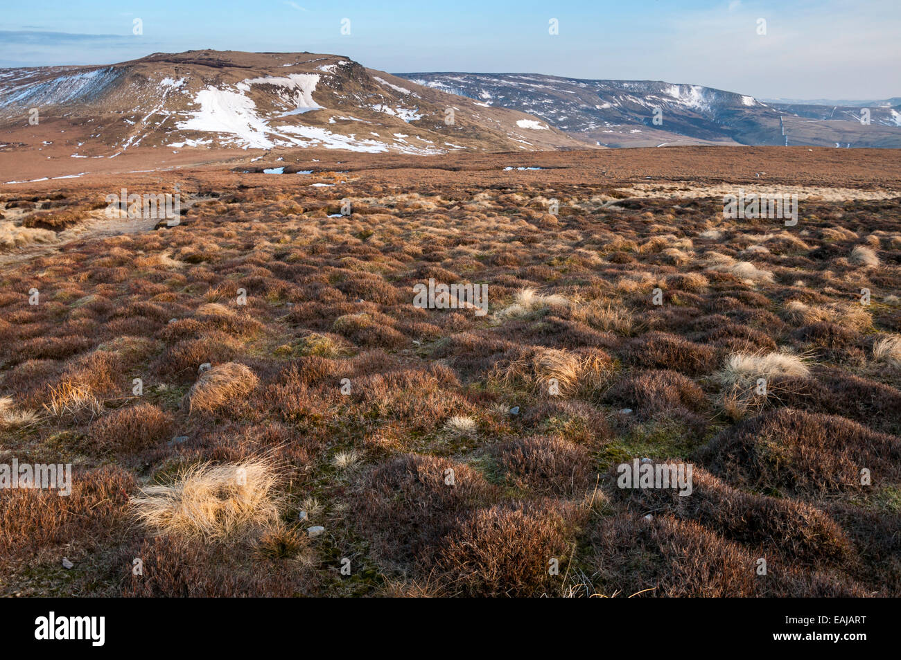 Drammatico paesaggio di brughiera con vista al Kinder Scout altopiano. Resti di tardo inverno neve. Foto Stock
