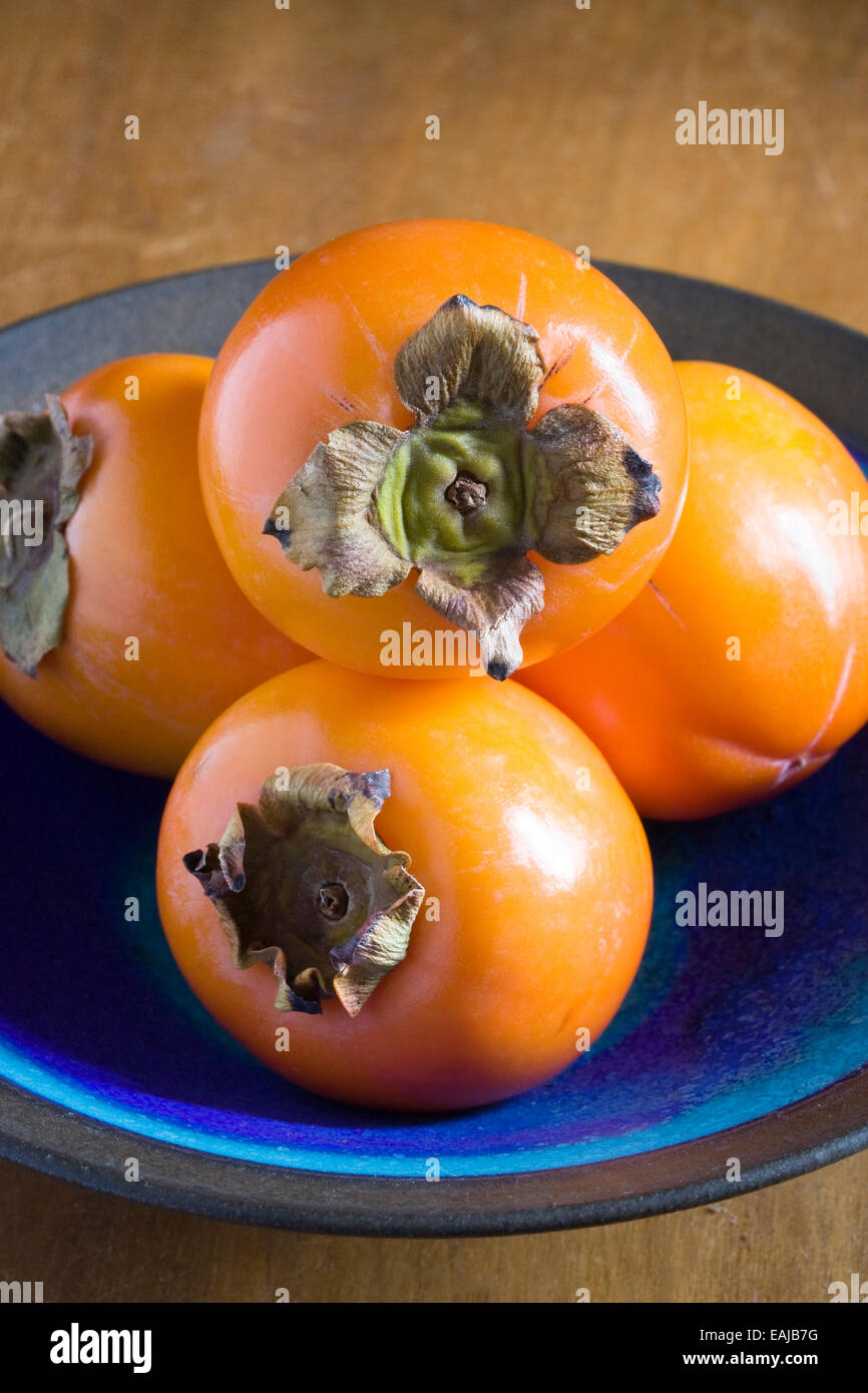 Persimmon frutto in una ciotola blu. Foto Stock