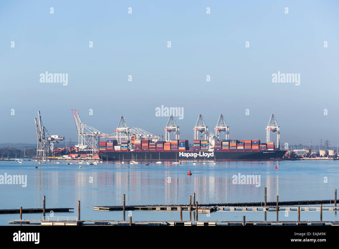 Enorme Hapag-Lloyd Container nave 'Shanghai Express' ormeggiato a Southampton Docks sul Solent, Hampshire, Regno Unito durante la giornata con un cielo blu chiaro Foto Stock