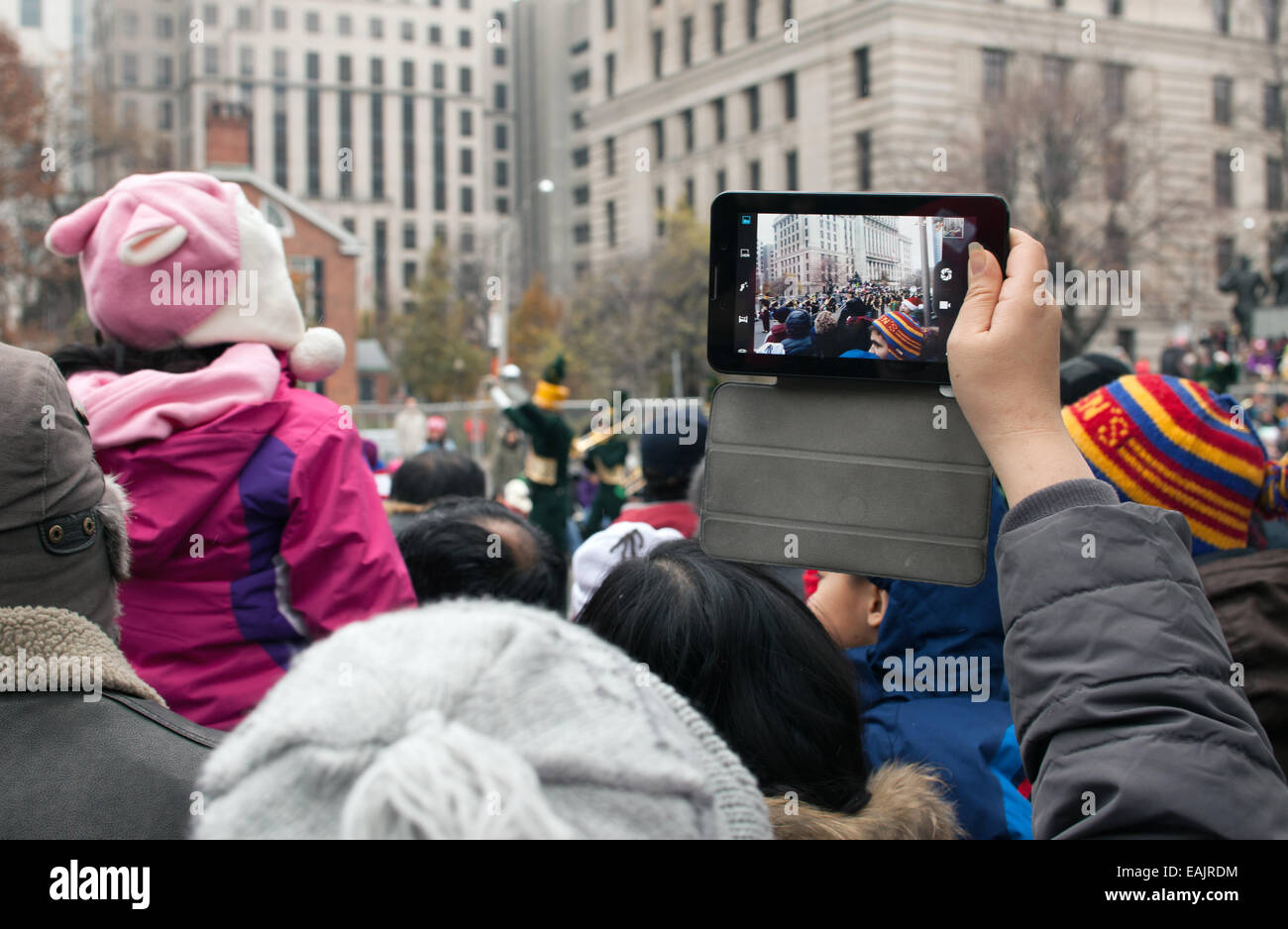 La donna sta immagine di Santa Claus Parade con il tablet. Novembre 16, 2014 a Toronto in Canada Foto Stock