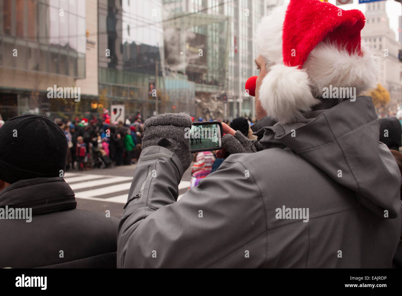 L'uomo le riprese di Santa Claus Parade con lo smartphone Novembre 16, 2014 a Toronto in Canada Foto Stock