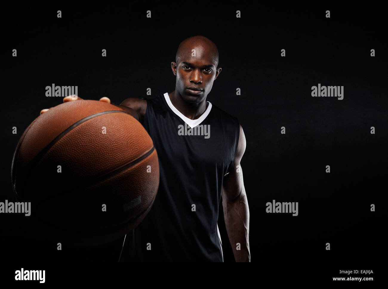Immagine del giovane americano africano uomo sportive in jersey tenendo un basket. Giocatore di pallacanestro professionale contro il nero. Foto Stock