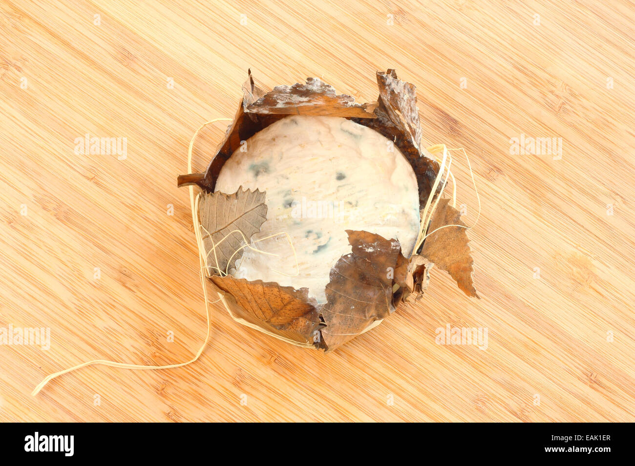 Formaggio di Banon avvolto con foglie sul pannello di legno Foto Stock