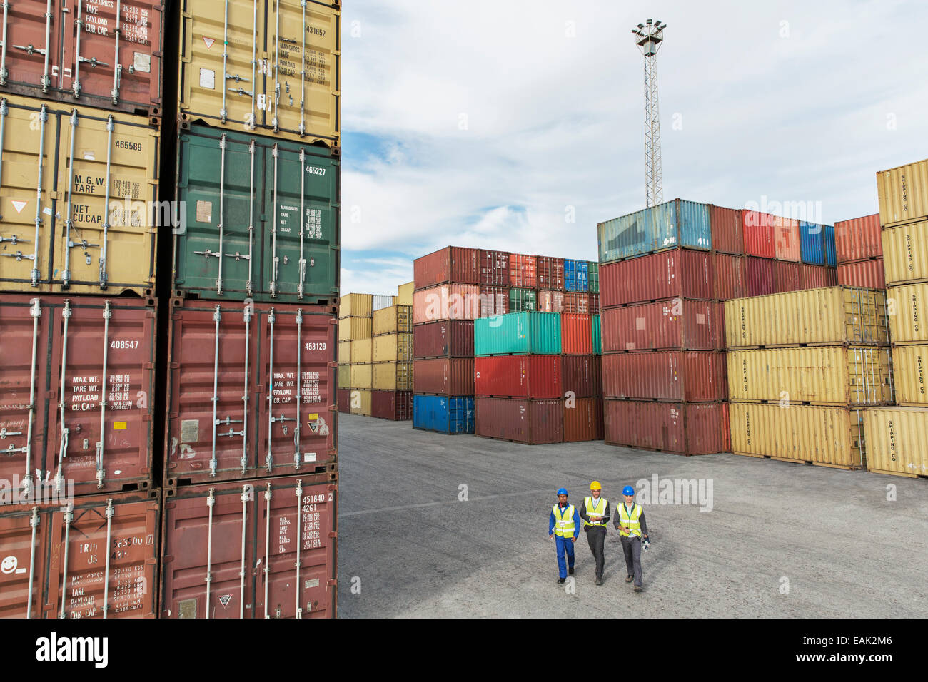 Imprenditori e lavoratori a piedi vicino ai contenitori di carico Foto Stock