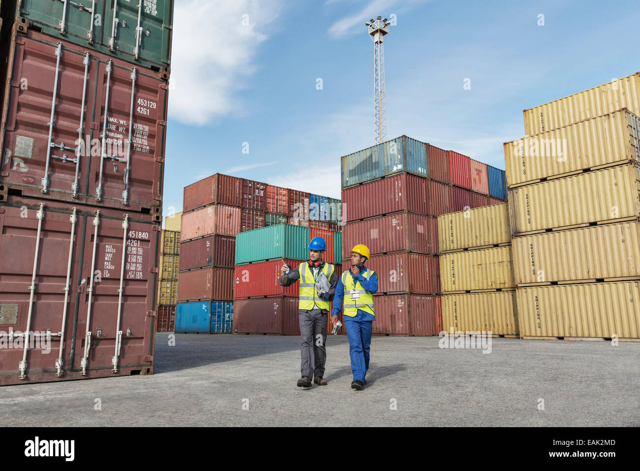 Lavoratore e imprenditore parlando vicino ai contenitori di carico Foto Stock