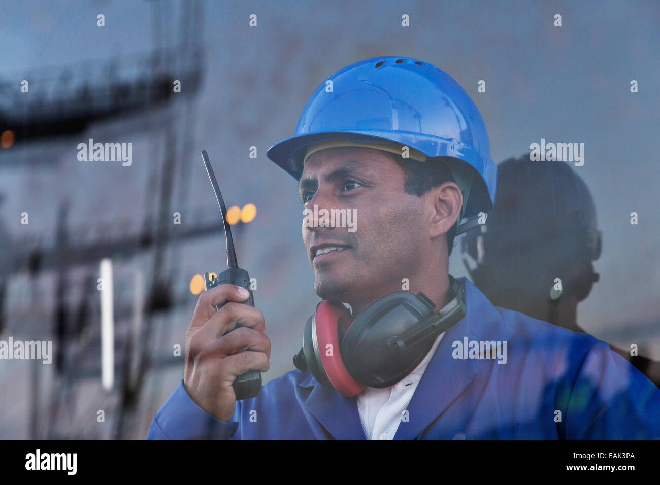 Lavoratore azienda walkie-talkie vicino a finestra Foto Stock