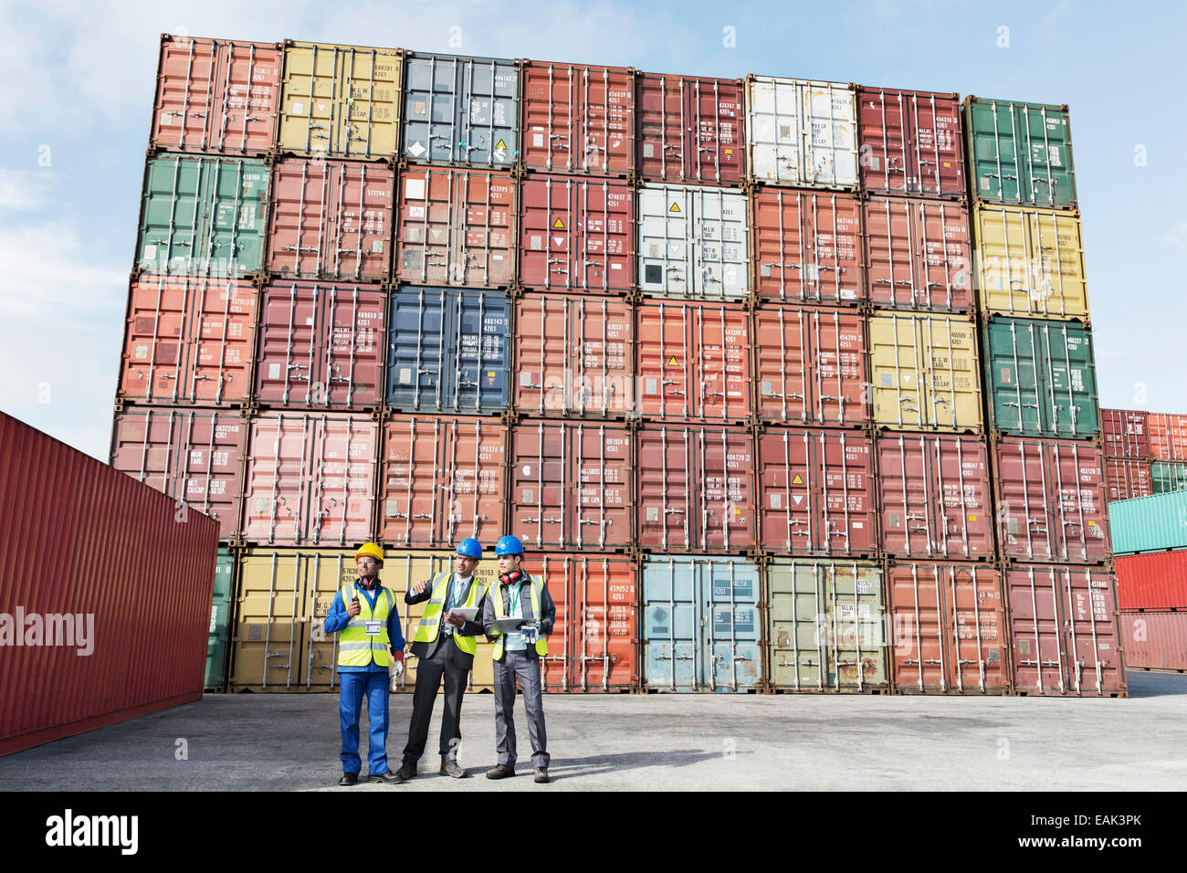 Lavoratore e imprenditori parlando vicino ai contenitori di carico Foto Stock