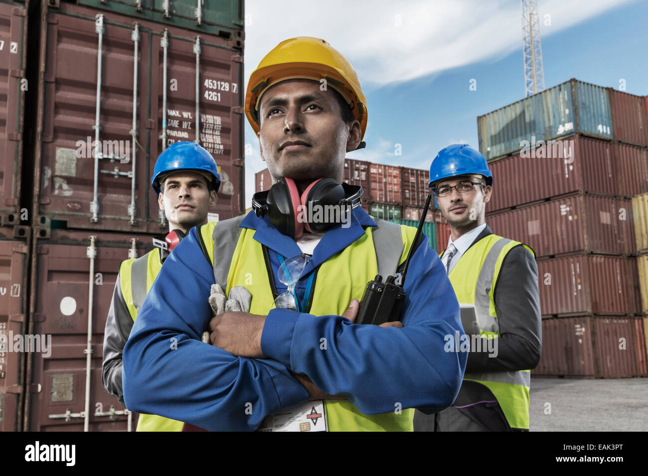 Lavoratore e imprenditori in piedi vicino ai contenitori di carico Foto Stock