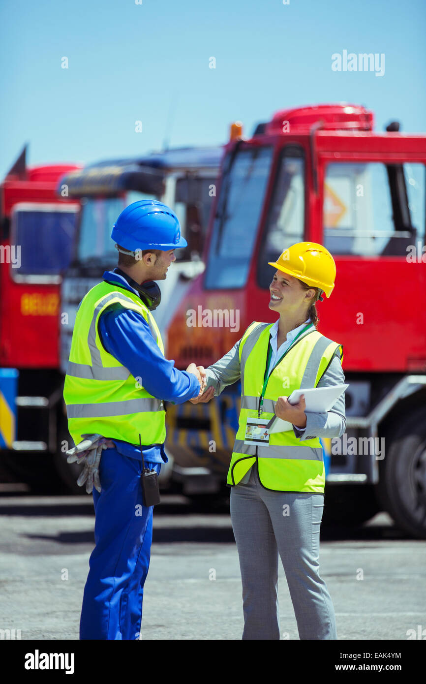 Imprenditrice e lavoratore stringono le mani vicino al camion Foto Stock