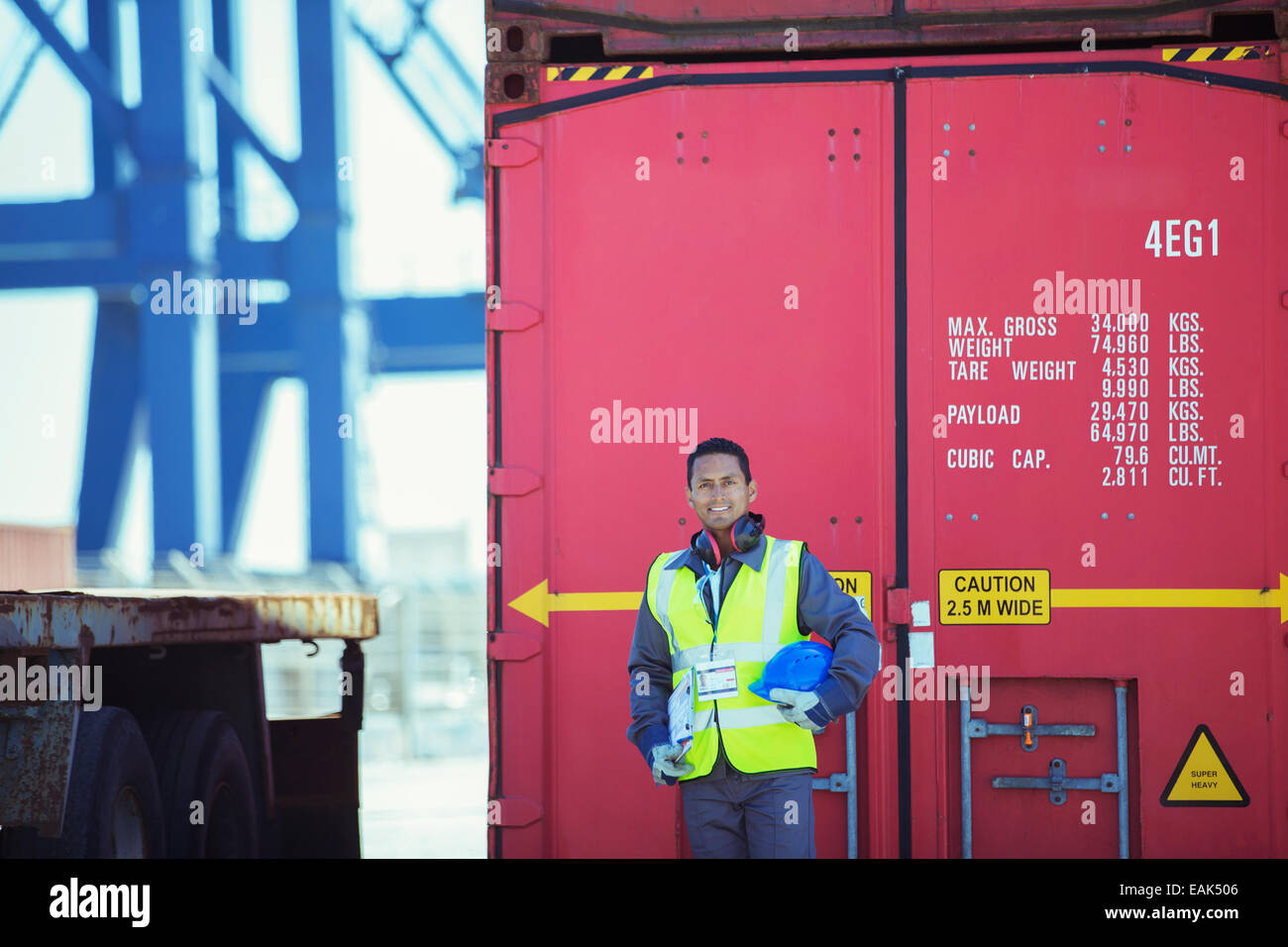 Lavoratore sorridendo vicino al contenitore di carico Foto Stock