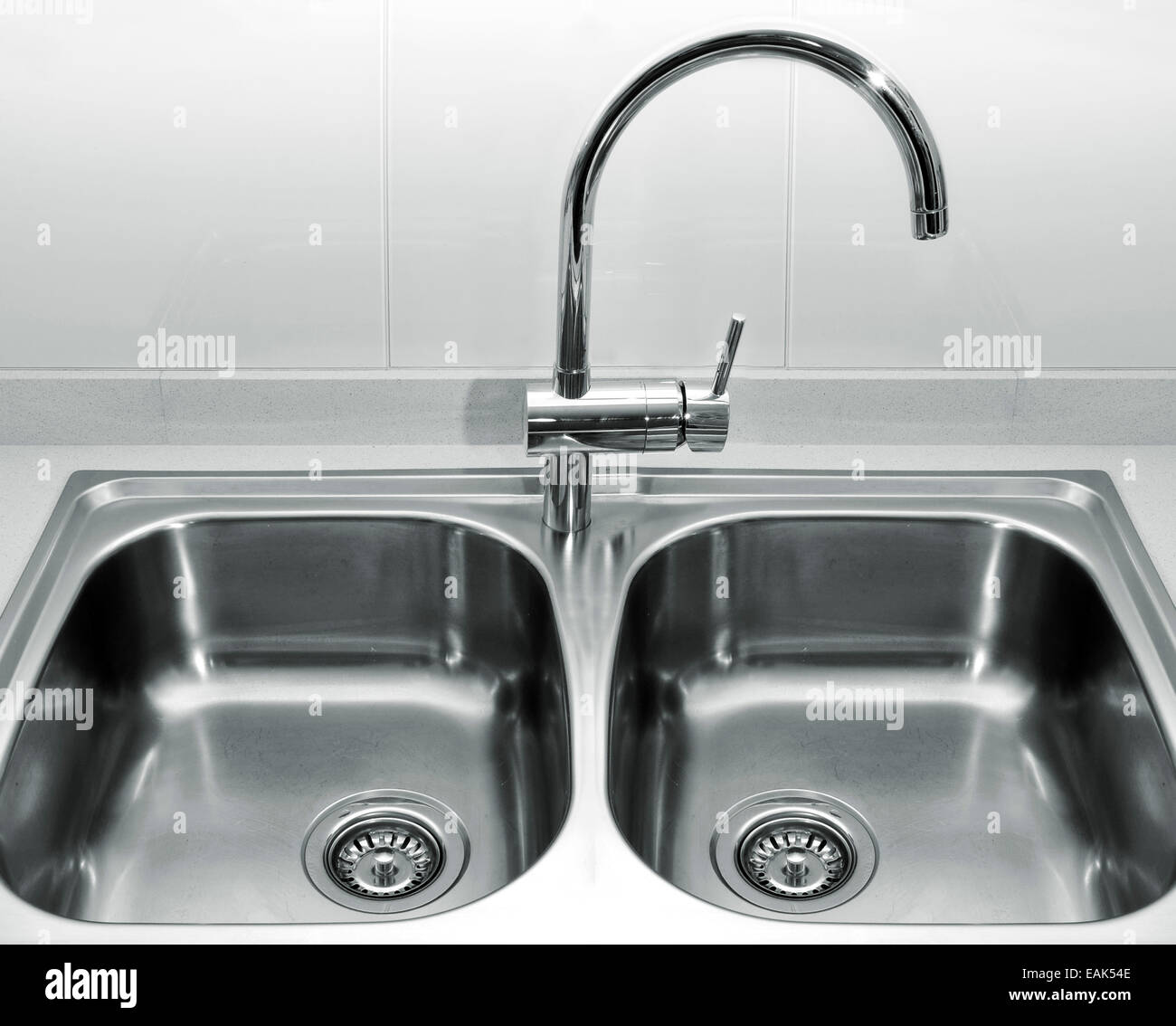 Una doppia vasca in acciaio inox lavello da cucina su un granito bianco piano di lavoro Foto Stock