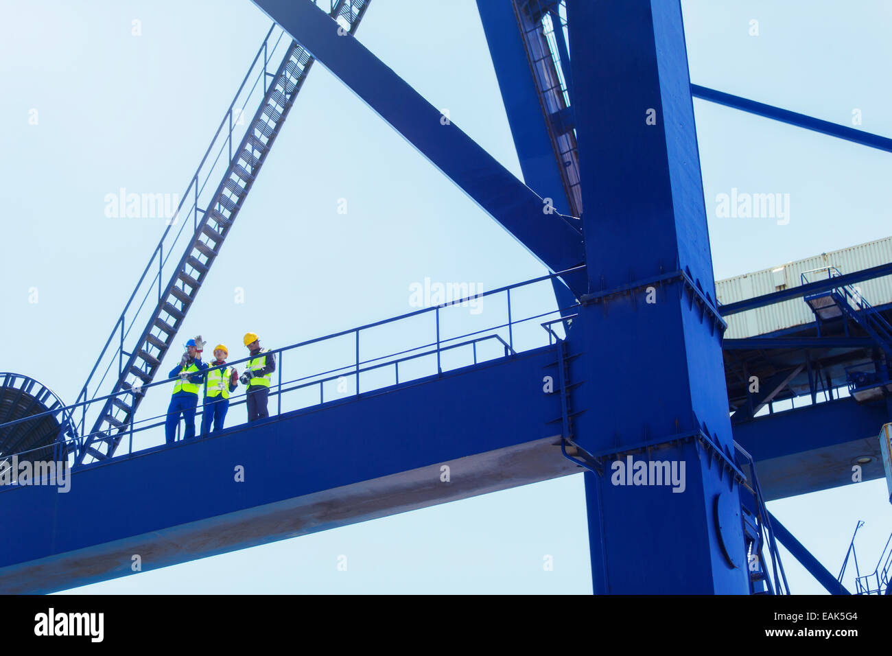 Basso angolo di visione dei lavoratori sulla gru di carico Foto Stock