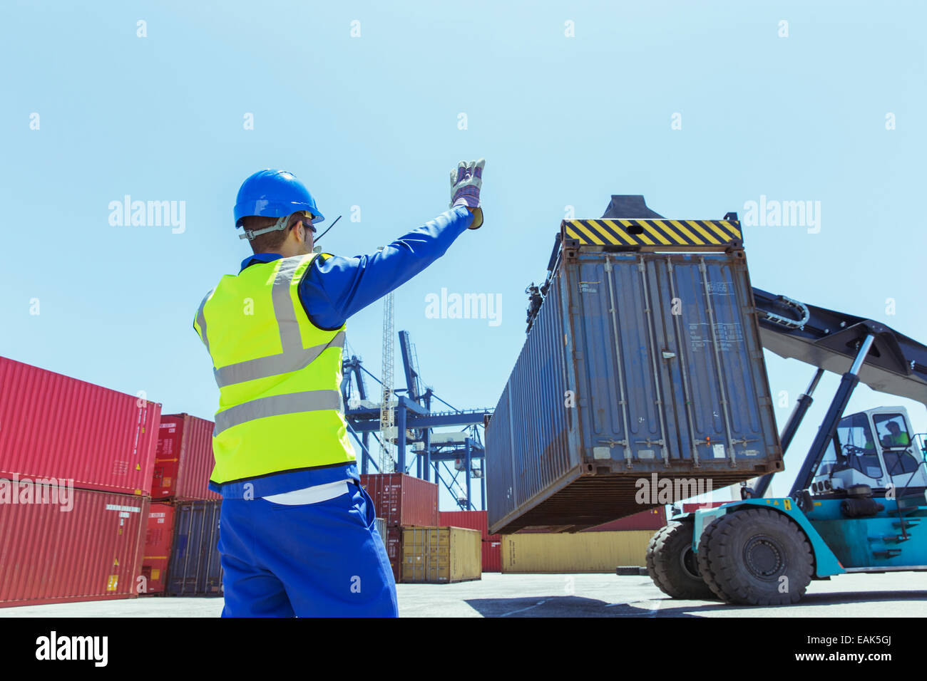 Lavoratore dirigere la gru che trasportano container Foto Stock