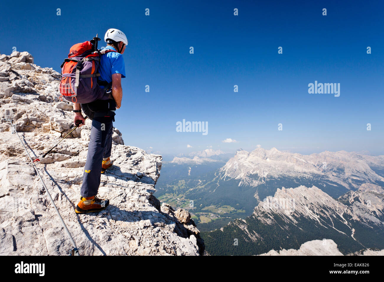 L'alpinista salendo la Via Ferrata Marino Bianchi arrampicata sul Monte Cristallo e si affaccia sulle Tofane Montagne Foto Stock