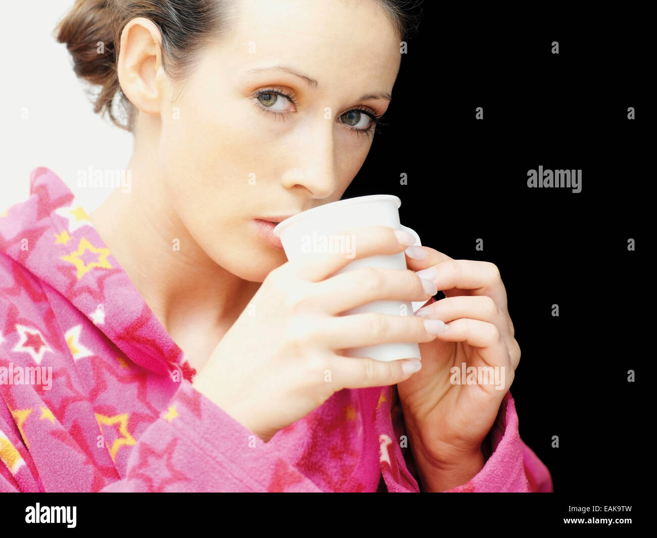Donna che indossa un accappatoio di bere il caffè Foto Stock
