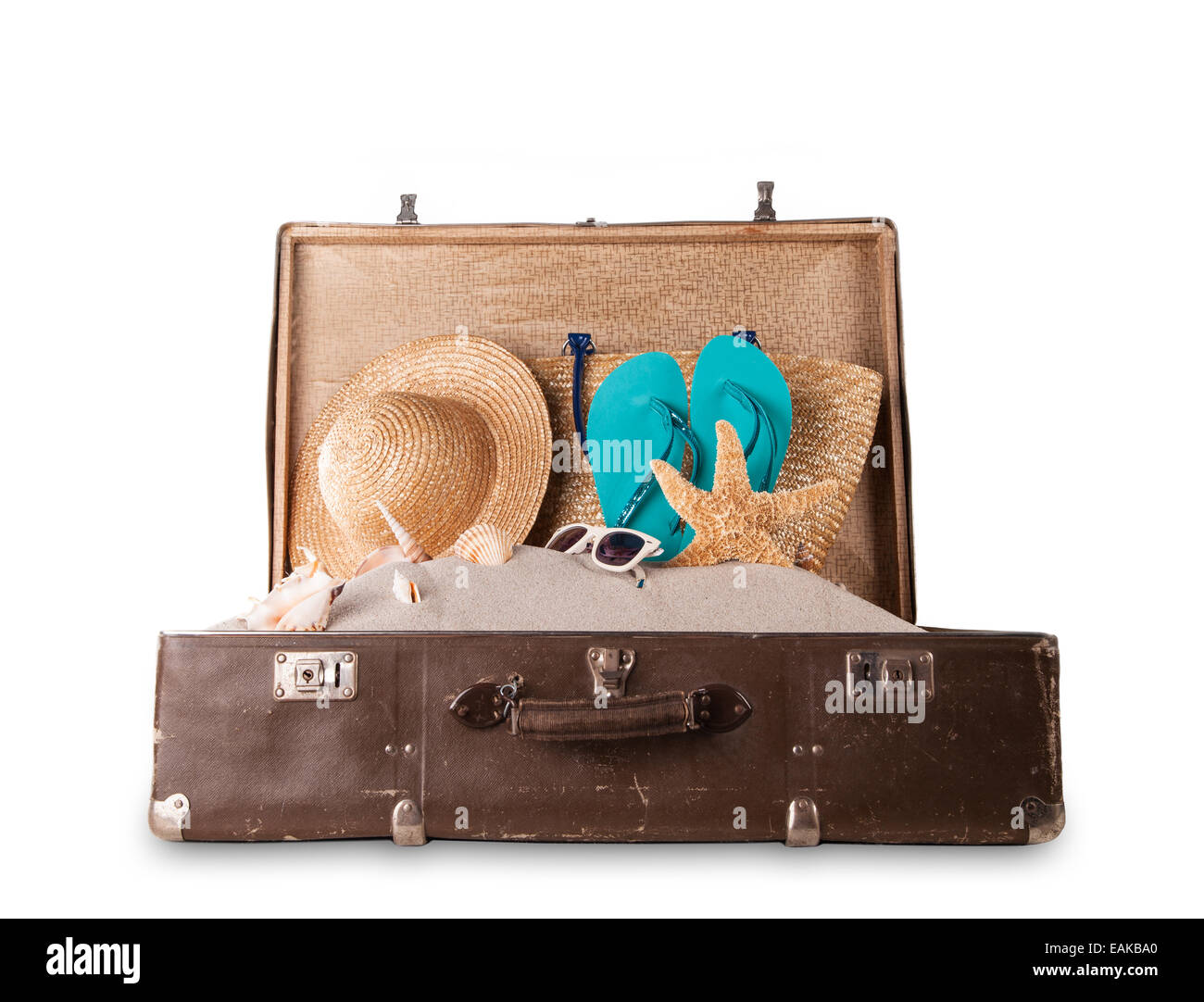 Colpo isolato di retro valigia con accessori sulla spiaggia Foto Stock