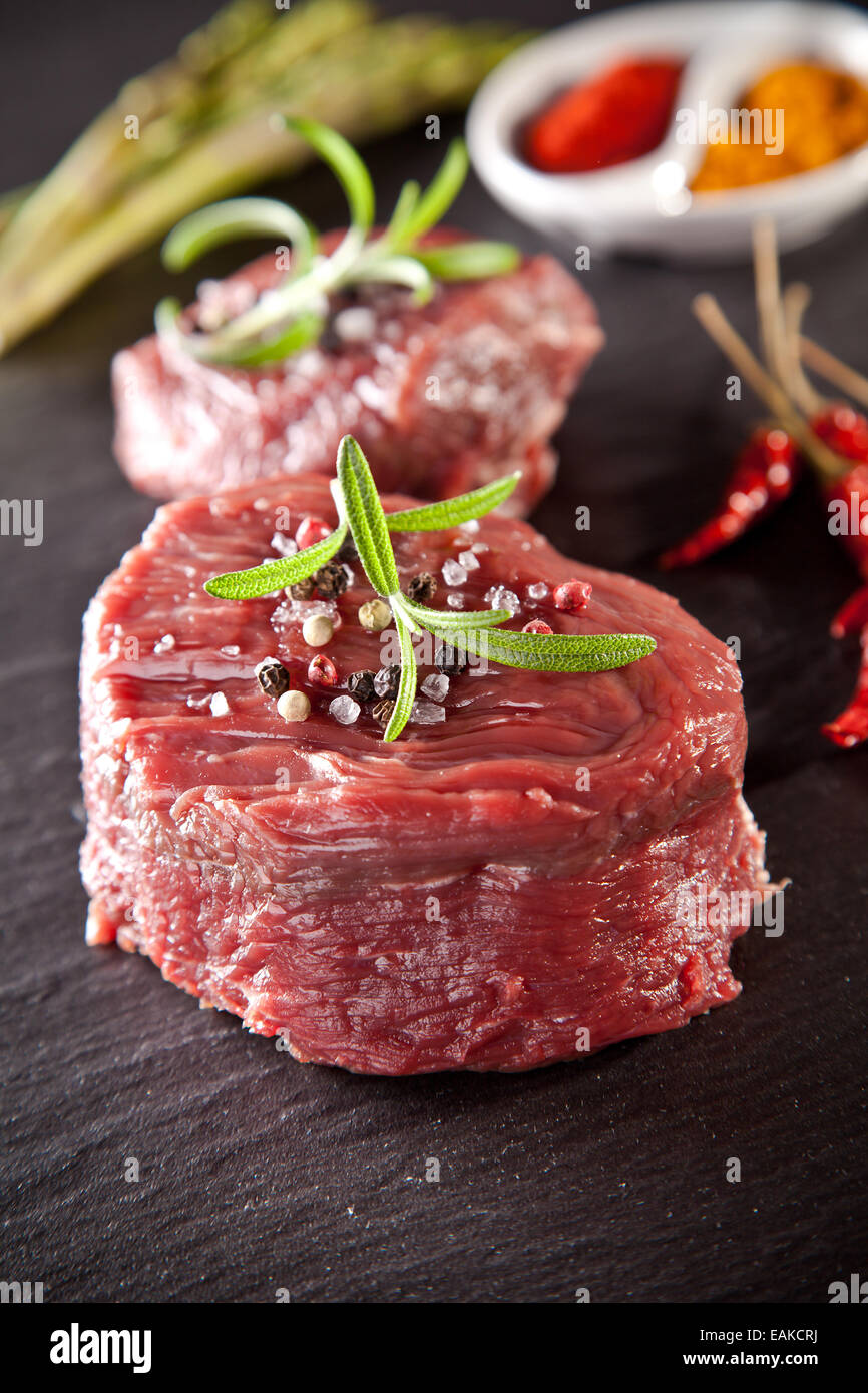 Pezzo di red raw bistecca di carne servita sulla pietra nera superficie. Foto Stock