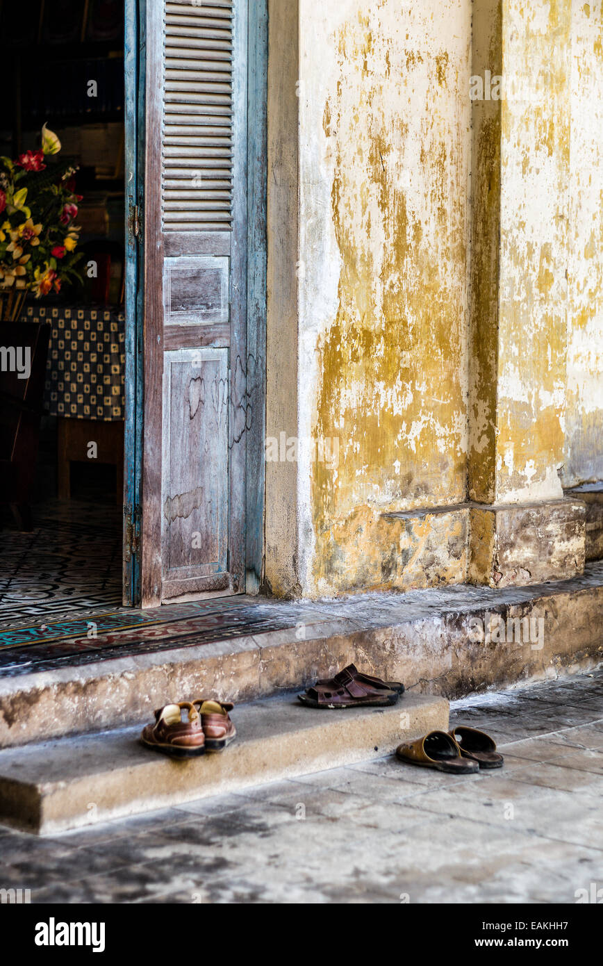 Scarpe fuori dalla porta del Vietnam di Theravada Khmer monastero Buddista in Tra Vinh. Foto Stock