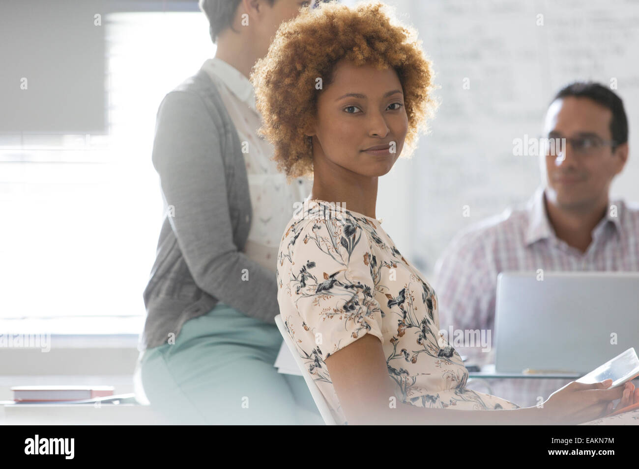 Ritratto di imprenditrice in ufficio, i colleghi in background Foto Stock