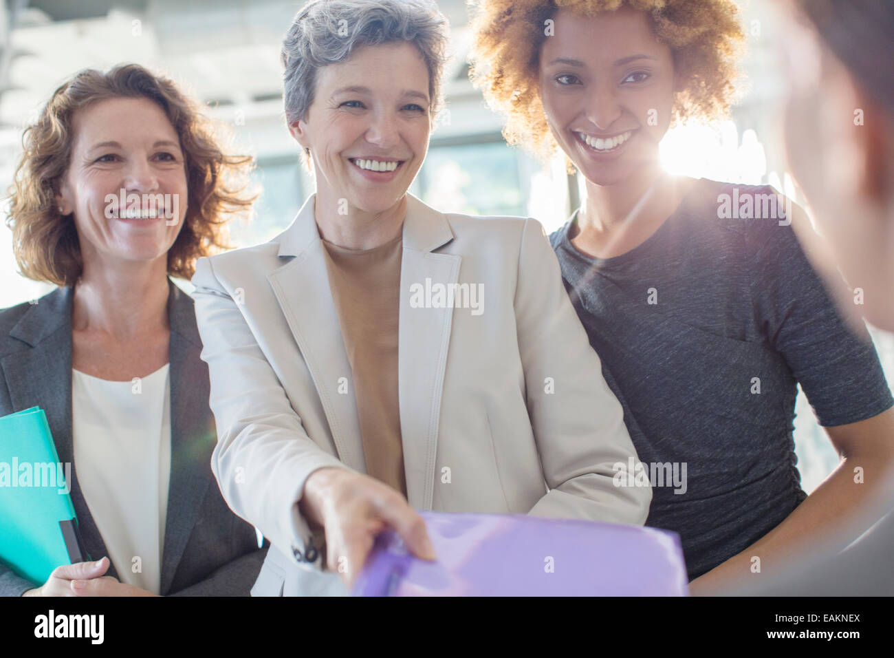 Tre sorridente imprenditrici azienda documenti Foto Stock