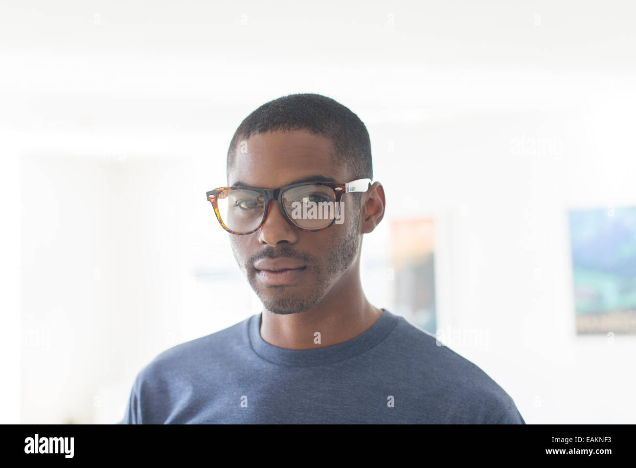 Ritratto di giovane imprenditore con gli occhiali in piedi in ufficio Foto Stock