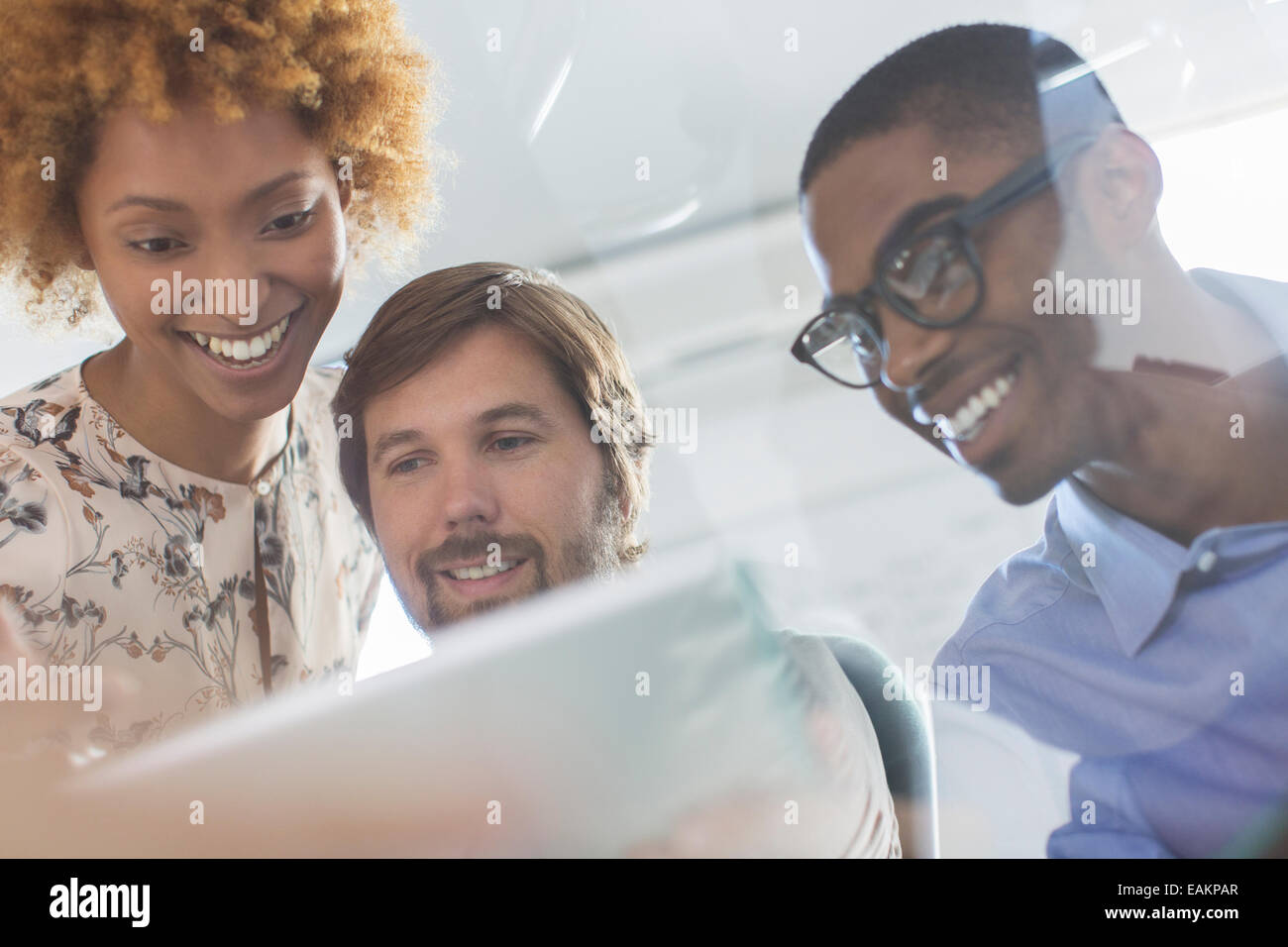 Basso angolo vista del team di office guardando a tavoletta digitale Foto Stock