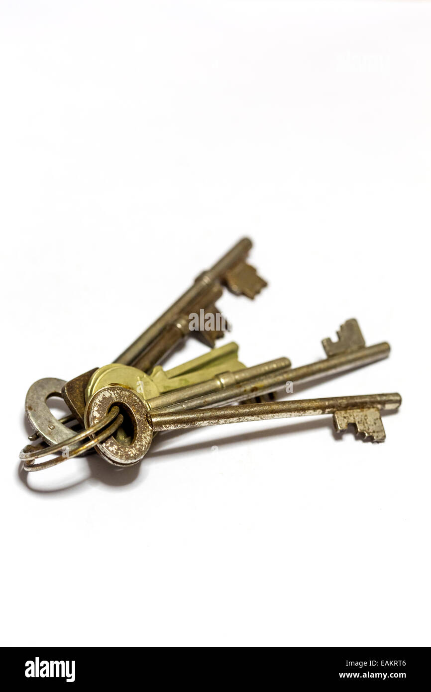Vecchie chiavi sul portachiavi su sfondo bianco Foto Stock