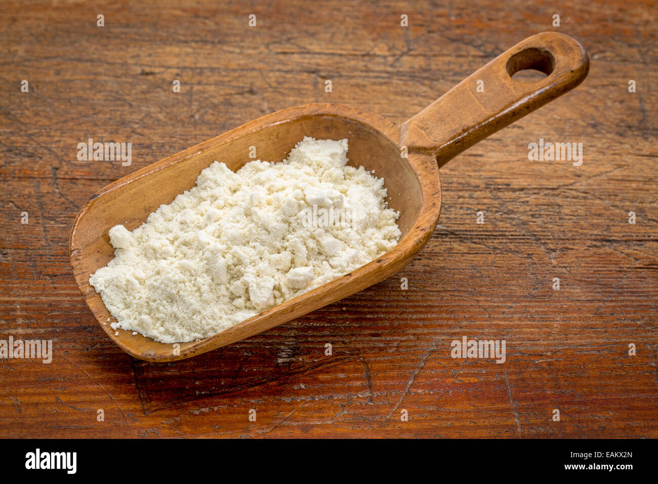 Scoop rustico di proteina di siero di latte in polvere contro il grunge tavolo in legno Foto Stock