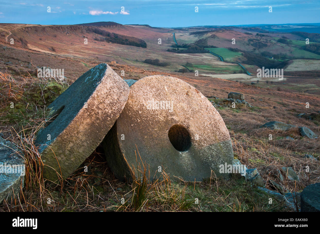 Macine in pietra sotto bordo Stanage al tramonto. Vista sul paesaggio colorato al di là con la strada in distanza. Foto Stock
