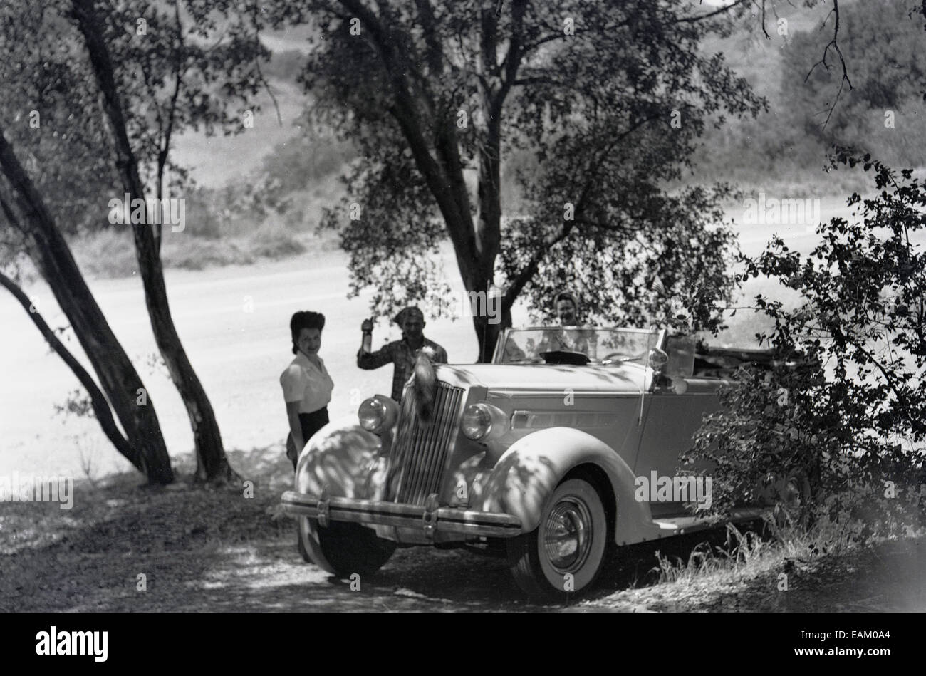 1940s, STATI UNITI D'AMERICA, storica foto scattata durante il WW11 che mostra un paio di un soldato e la sua ragazza al di fuori con le loro auto in campagna. Foto Stock