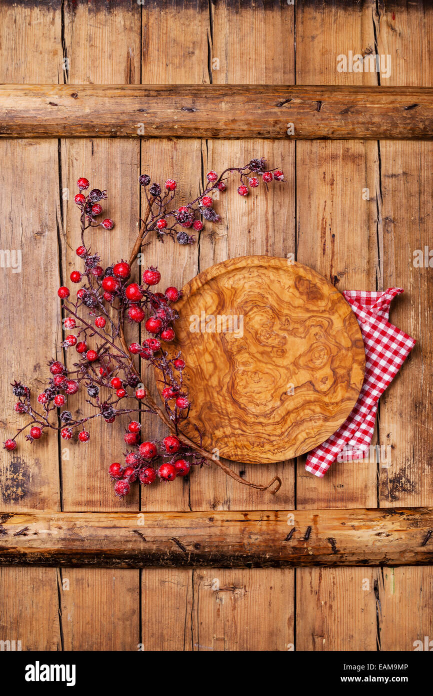 Piastra rotonda e succursale con bacche rosse su legno sfondo texture Foto Stock