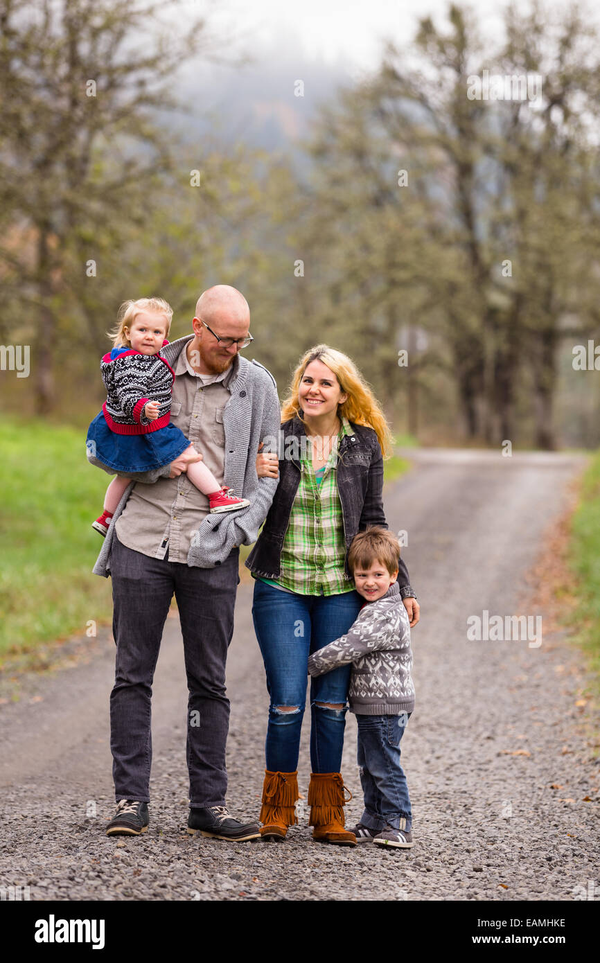 Foto di famiglia di una madre, padre e i loro due bambini di un ragazzo e una ragazza all'aperto in autunno. Foto Stock