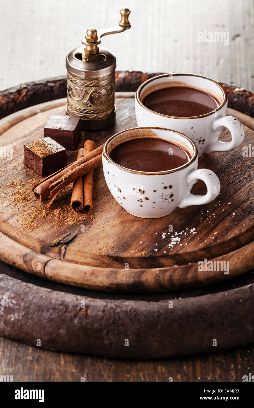 Cioccolato caldo cosparso con il cioccolato bianco e spezie scuro su sfondo di legno Foto Stock