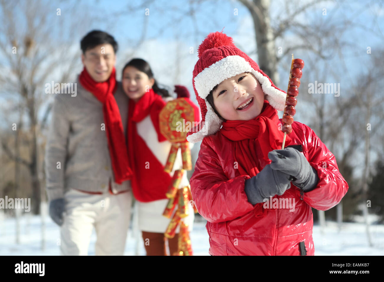 Il ragazzo con rivestite di zucchero berry e genitori nel outdoor Foto Stock
