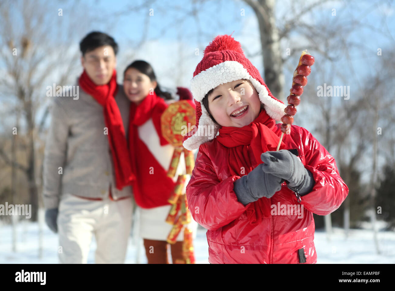 Il ragazzo con rivestite di zucchero berry e genitori nel outdoor Foto Stock