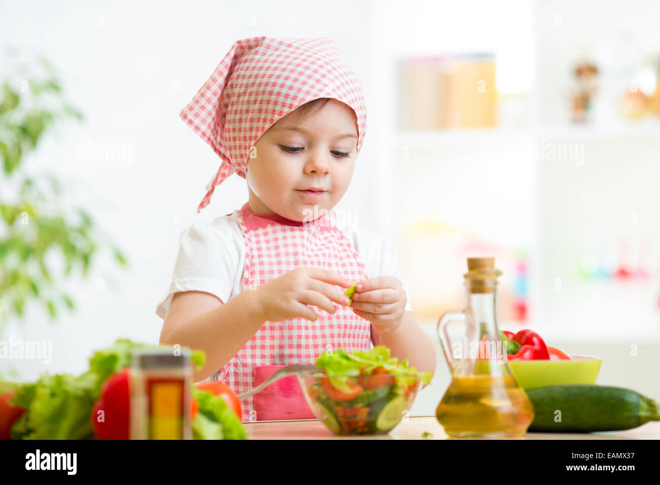 Cuocere kid girl preparare verdura Foto Stock