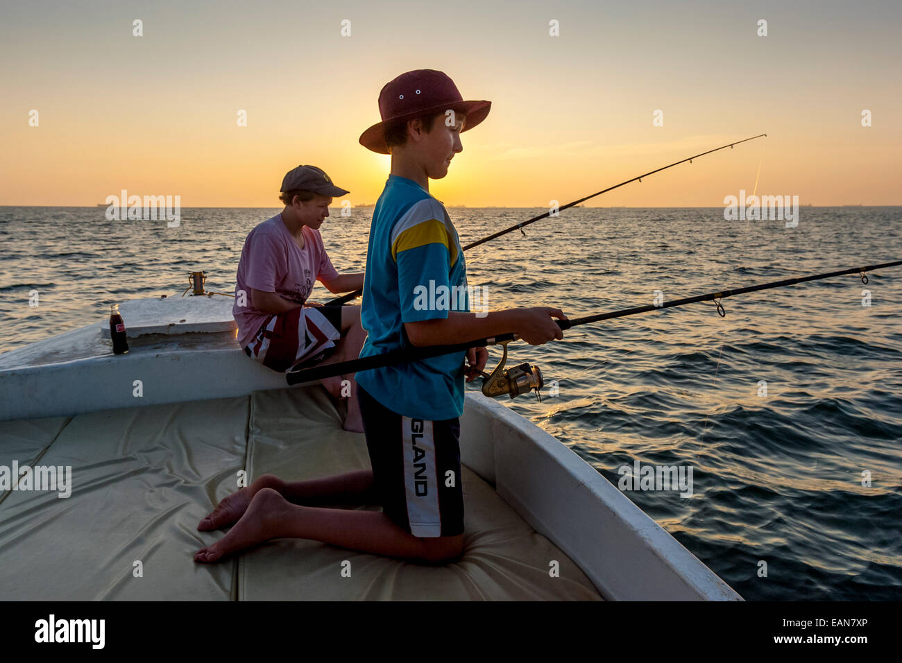 Due giovani turisti britannici su un tramonto viaggio di pesca, Goa, India Foto Stock