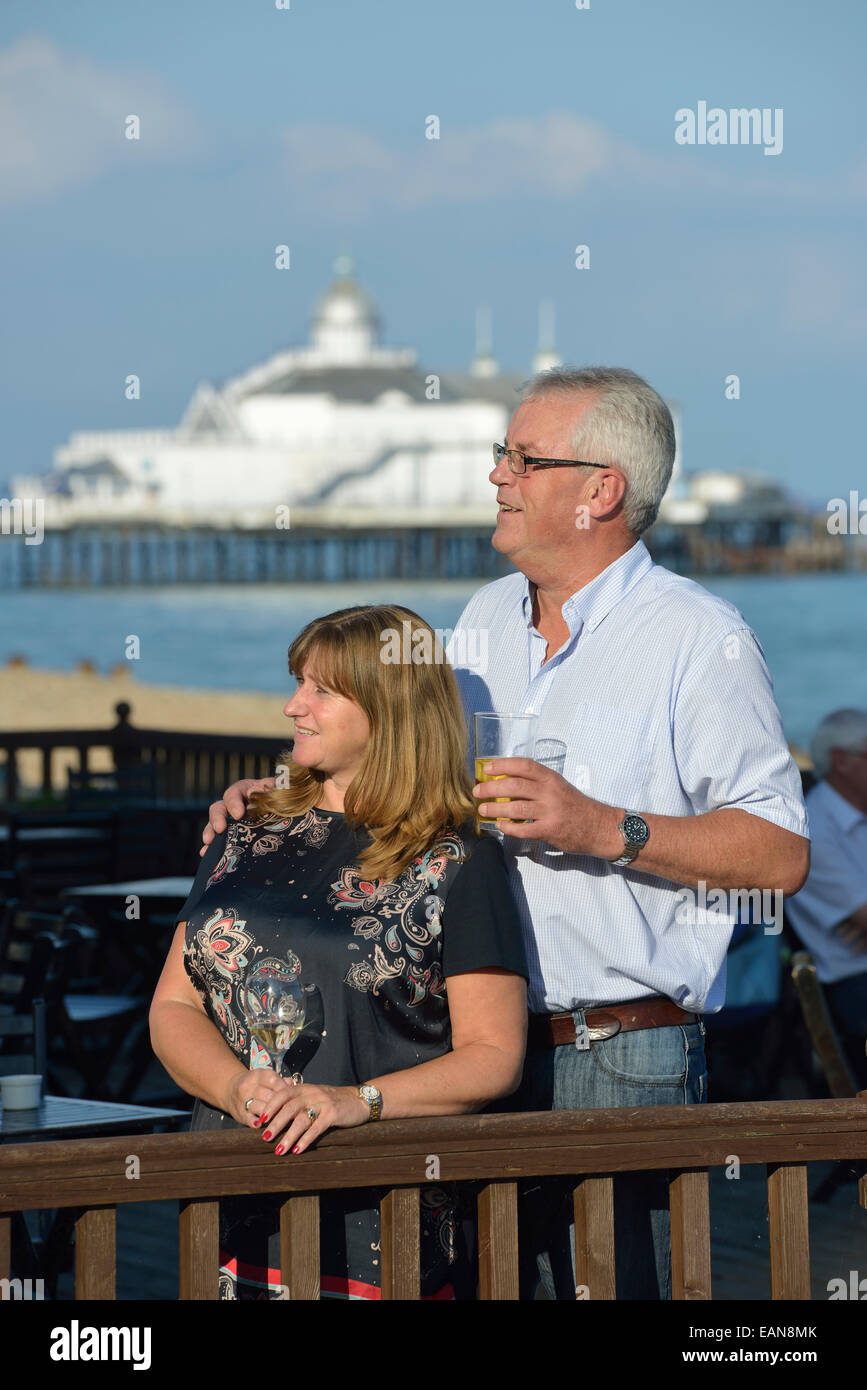 Adulto Giovane gustando un drink serale insieme a un caffè sulla spiaggia sul lungomare di Eastbourne. East Sussex. Regno Unito Foto Stock