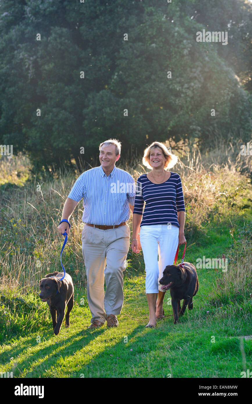 Una coppia matura a piedi i loro cani sulla South Downs, Eastbourne. East Sussex, Regno Unito Foto Stock