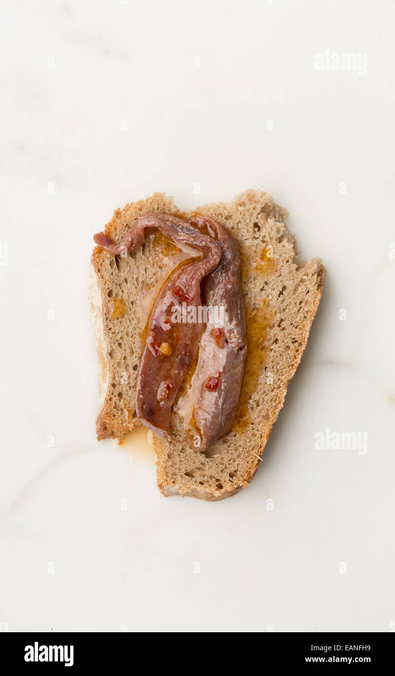 Filetti di Alici con peperoncino e olio su una fetta di pane di segale Foto Stock