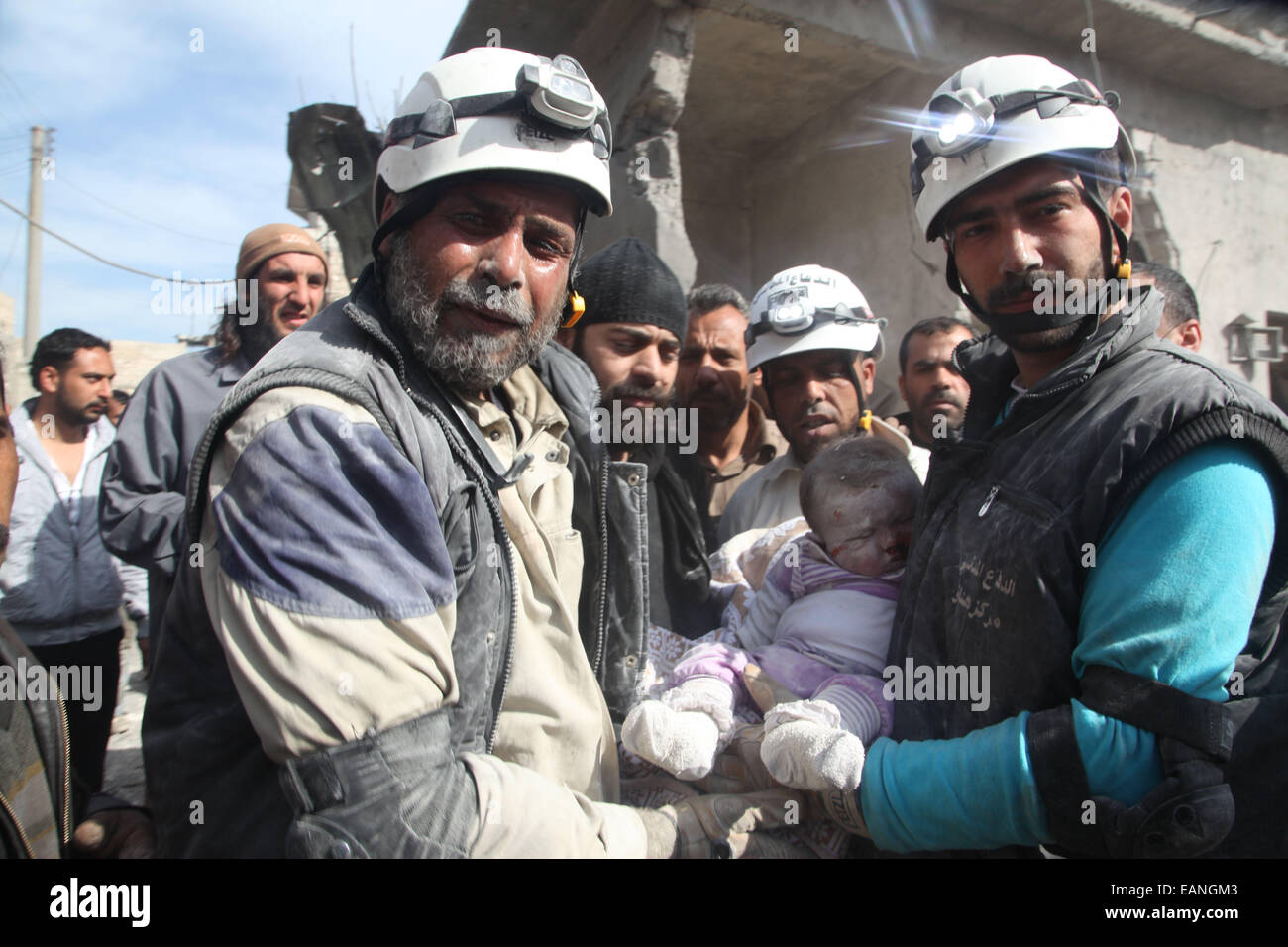 Aleppo, Siria. 24 Mar, 2014. Due di salvataggio volontario estraendo il cadavere di baby femmina dai detriti in seguito ad un bombardamento con un barrell bomba. I civili e soccorritori rispondere ad un case ridotte in detriti dall'esercito siriano la decorticatura. © Medyan Dairieh/ZUMA filo/ZUMAPRESS.com/Alamy Live News Foto Stock