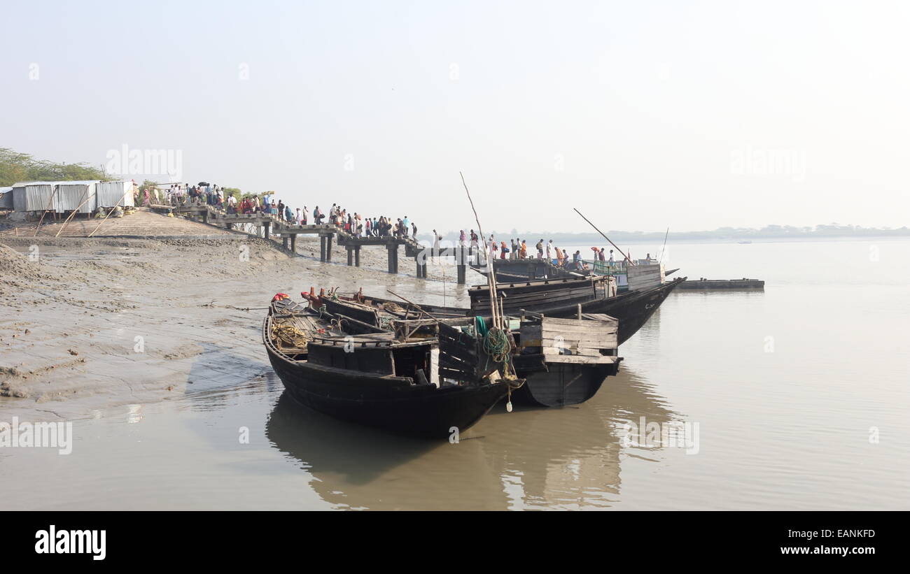 I grandi gruppi di persone attraversano il fiume ogni giorno in barche per raggiungere le loro case. Foto Stock