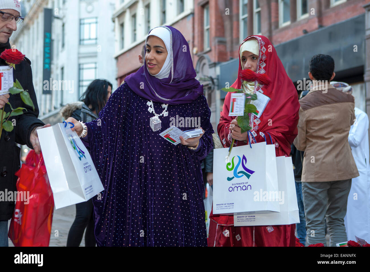 Le donne in arabo Omani arabo tradizionale accappatoi  Oman di promozione del turismo in Market Street, Piccadilly, Manchester, Regno Unito Foto Stock