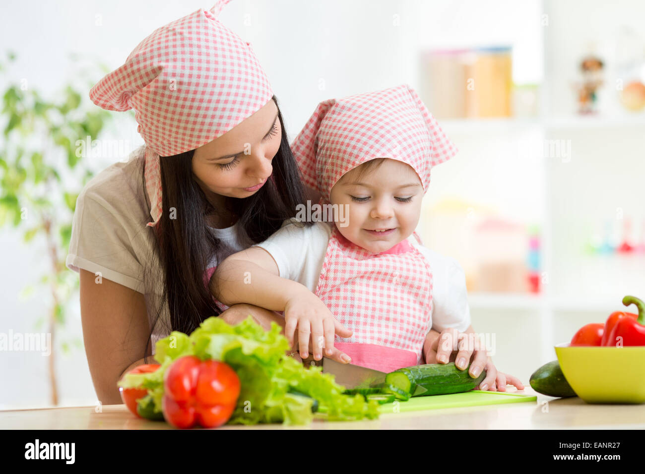 La Madre insegna figlia coltello tagliare il cetriolo Foto Stock